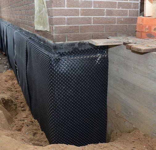 Structural waterproofing material applied to an external wall surface